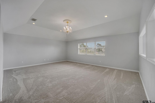 spare room featuring a chandelier and carpet flooring