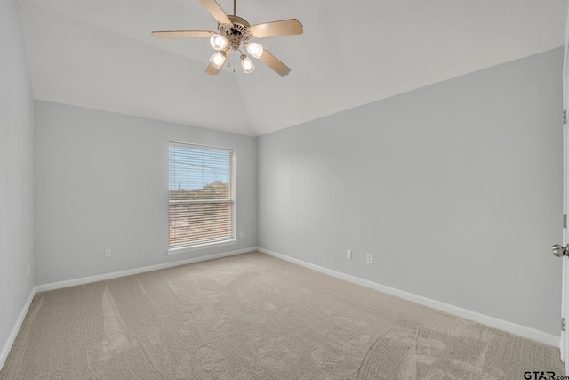 empty room featuring lofted ceiling, light colored carpet, and ceiling fan