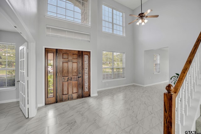 entrance foyer with a towering ceiling, ceiling fan, and a wealth of natural light