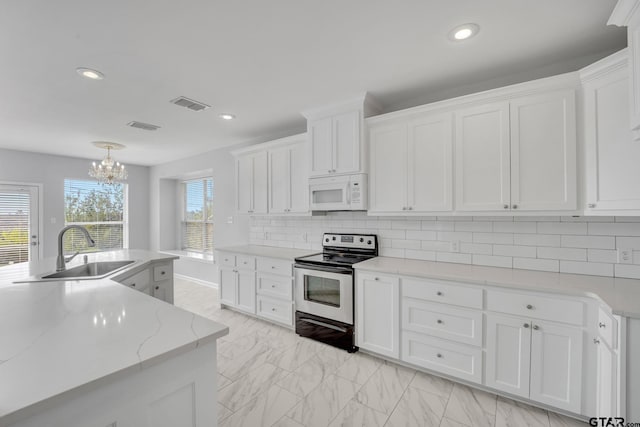 kitchen with white cabinets, sink, stainless steel range with electric cooktop, and decorative backsplash