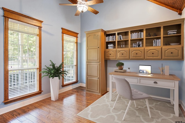 home office with light wood finished floors, baseboards, built in desk, and ceiling fan
