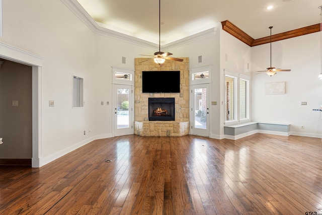 unfurnished living room featuring a ceiling fan, crown molding, and a fireplace