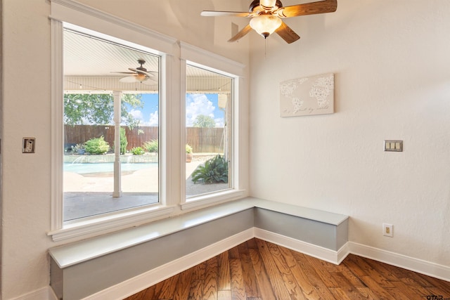 spare room featuring baseboards, a ceiling fan, and wood finished floors