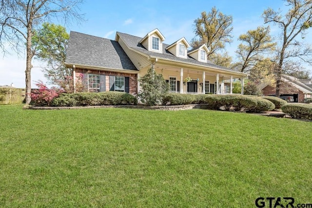 new england style home featuring a front yard and covered porch