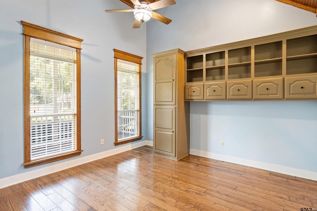 unfurnished room with light wood-style floors, baseboards, and ceiling fan