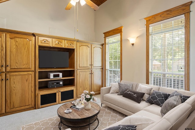 carpeted living room with high vaulted ceiling and ceiling fan