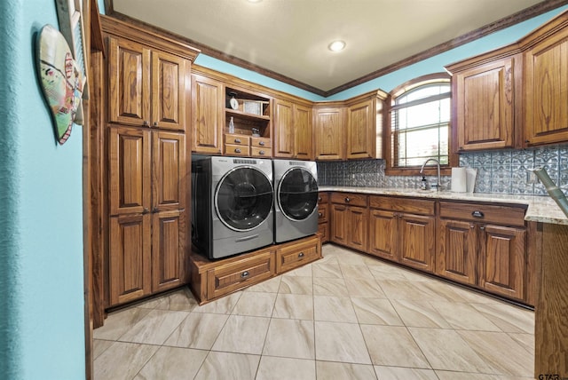 washroom featuring cabinets, light tile patterned flooring, sink, ornamental molding, and washer and dryer