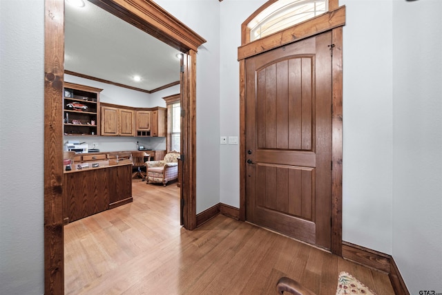 entrance foyer with light hardwood / wood-style floors and ornamental molding