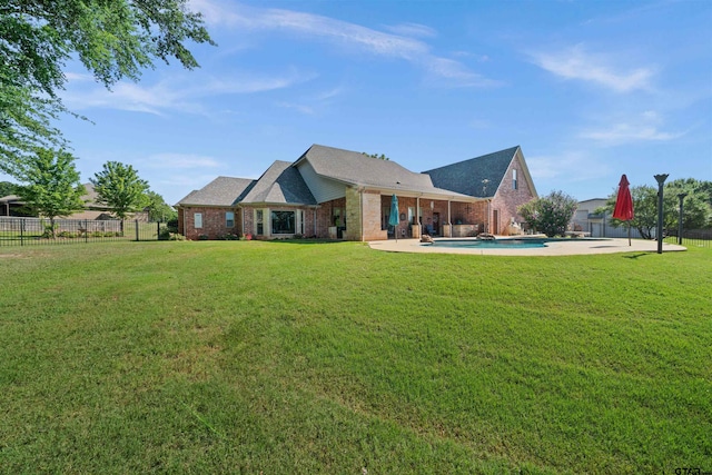 back of house with a fenced in pool, a patio, and a lawn