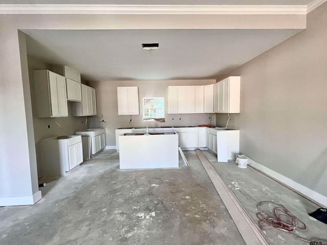 kitchen with a kitchen island, white cabinetry, and ornamental molding