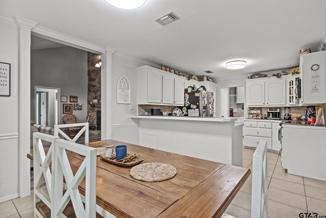 dining space with light tile patterned floors and ornamental molding