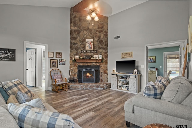 living room featuring a fireplace, hardwood / wood-style floors, high vaulted ceiling, and ceiling fan