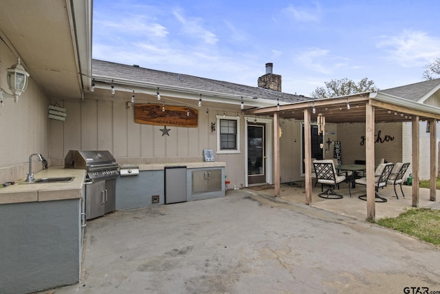 view of patio with exterior kitchen, sink, and grilling area