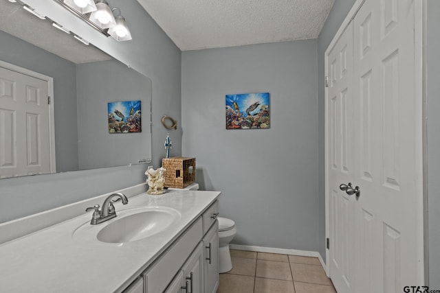 bathroom featuring tile patterned floors, vanity, toilet, and a textured ceiling