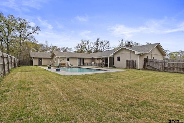 back of property with a fenced backyard, a fenced in pool, a lawn, and a patio