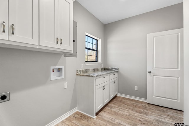 laundry area featuring cabinets, electric dryer hookup, hookup for a washing machine, and light wood-type flooring