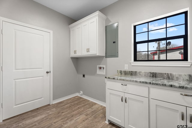 washroom with hookup for a washing machine, electric panel, cabinets, wood-type flooring, and hookup for an electric dryer