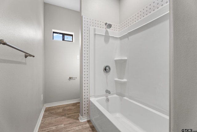 bathroom featuring hardwood / wood-style floors and bathing tub / shower combination