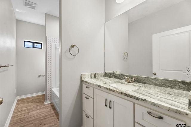 bathroom featuring hardwood / wood-style flooring, vanity, and shower / bath combination