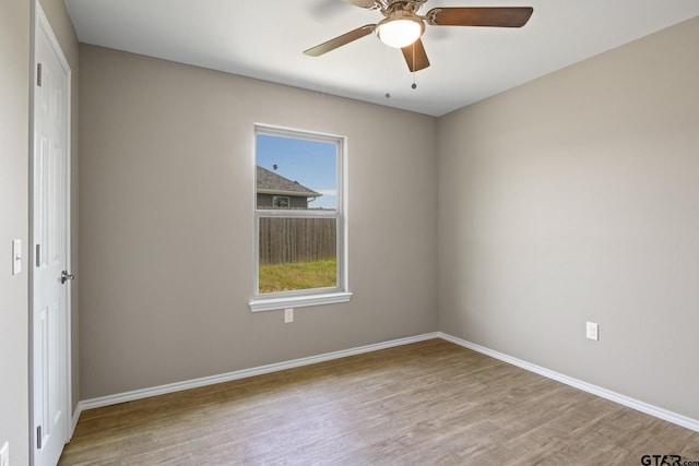 spare room with wood finished floors, baseboards, and ceiling fan