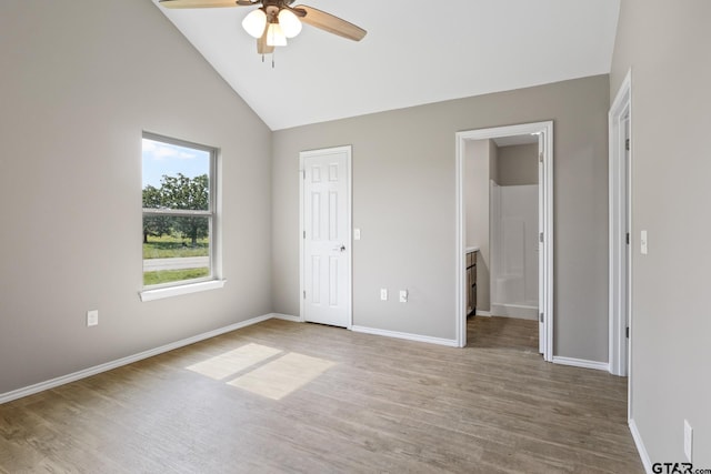 unfurnished bedroom featuring wood finished floors, lofted ceiling, baseboards, connected bathroom, and ceiling fan