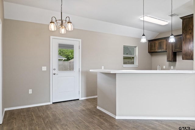 kitchen with dark brown cabinetry, dark wood finished floors, baseboards, decorative light fixtures, and vaulted ceiling