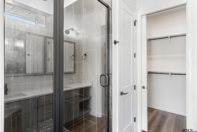 bathroom featuring wood-type flooring and an enclosed shower