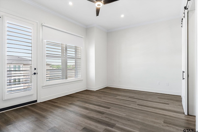 unfurnished room featuring ceiling fan, a barn door, dark hardwood / wood-style floors, and crown molding