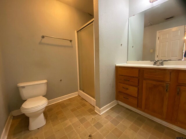 bathroom with vanity, toilet, and a shower with shower door