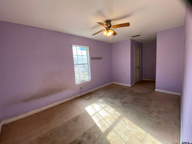 spare room featuring ceiling fan and light carpet