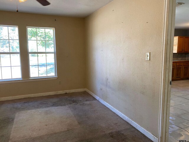 empty room featuring ceiling fan and light tile patterned flooring