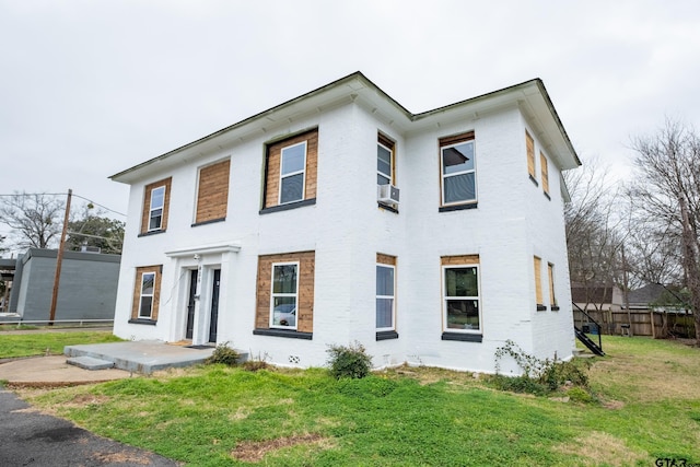 view of front facade featuring a patio, cooling unit, and a front lawn