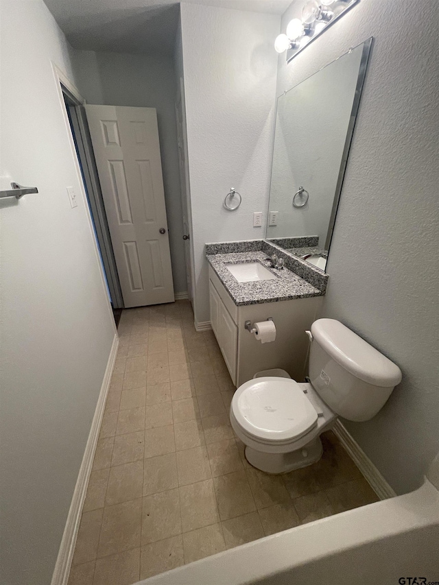 bathroom featuring vanity, tile patterned floors, toilet, and baseboards