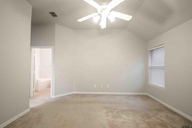 spare room featuring a ceiling fan, visible vents, carpet floors, baseboards, and lofted ceiling