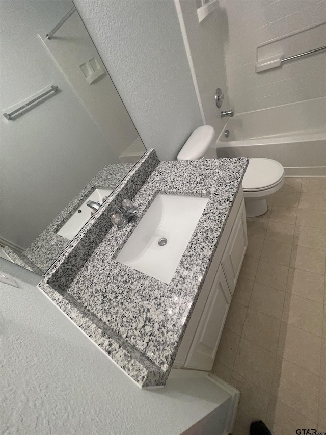 full bathroom with tile patterned floors, toilet, vanity, and washtub / shower combination