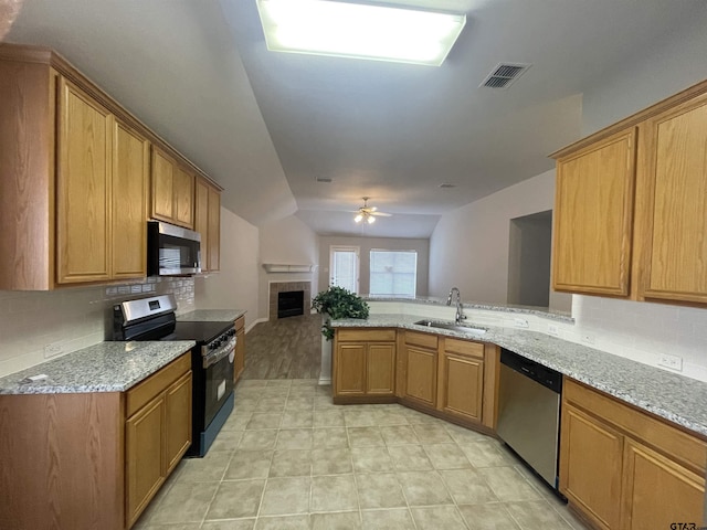 kitchen with visible vents, open floor plan, a peninsula, stainless steel appliances, and a sink