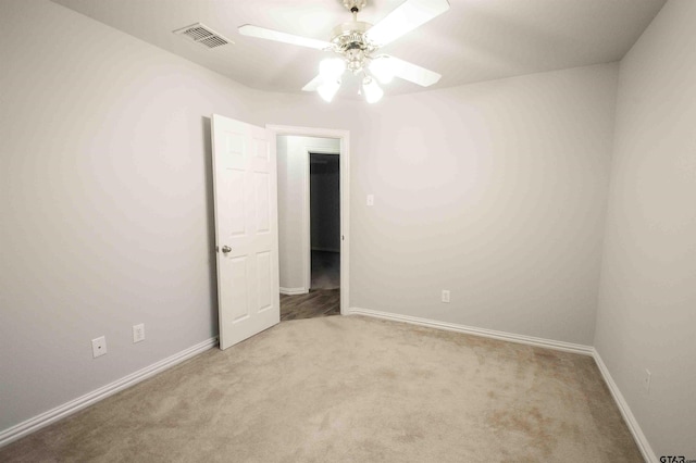 unfurnished room featuring carpet flooring, baseboards, visible vents, and ceiling fan