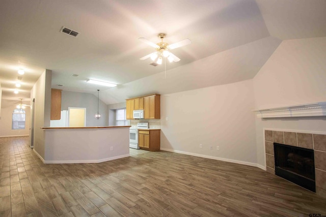 kitchen featuring white appliances, a ceiling fan, visible vents, vaulted ceiling, and a tiled fireplace