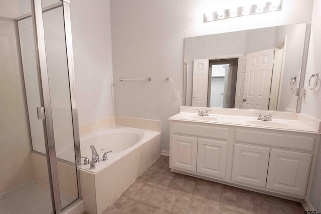 full bathroom featuring double vanity, a whirlpool tub, a stall shower, and a sink