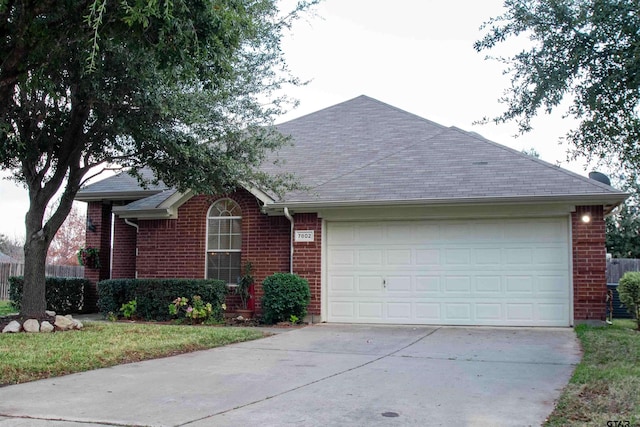 single story home with brick siding, a shingled roof, fence, concrete driveway, and an attached garage