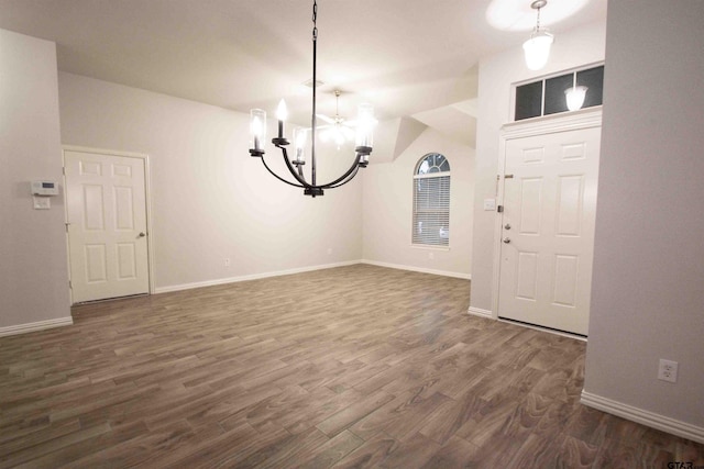 foyer entrance with dark wood finished floors, a notable chandelier, and baseboards