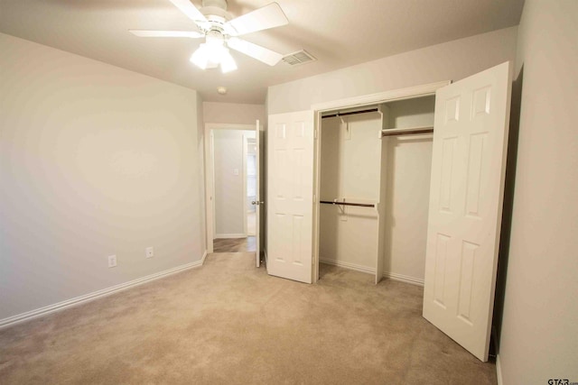 unfurnished bedroom with a closet, visible vents, light colored carpet, and baseboards