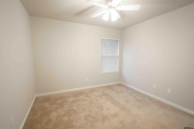 empty room with ceiling fan, baseboards, and carpet