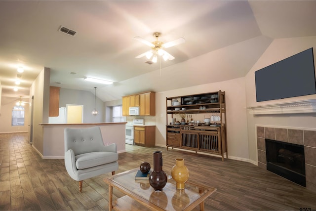 living room featuring visible vents, dark wood-type flooring, a ceiling fan, vaulted ceiling, and a tile fireplace