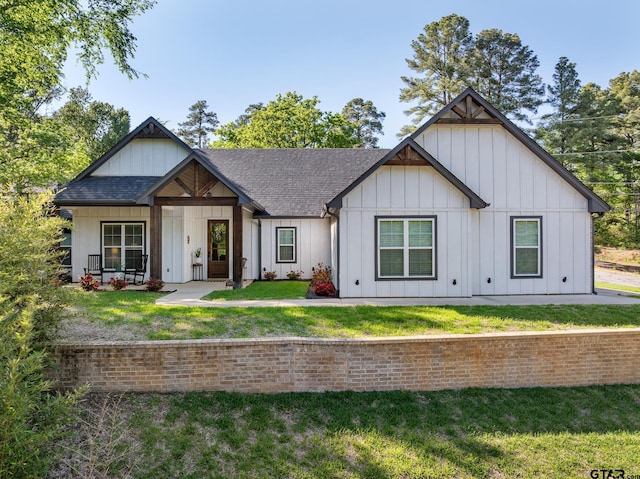 2853 S Robertson, Tyler, TX 75701 - view of front of home featuring roof with shingles, board and batten siding, and a front yard