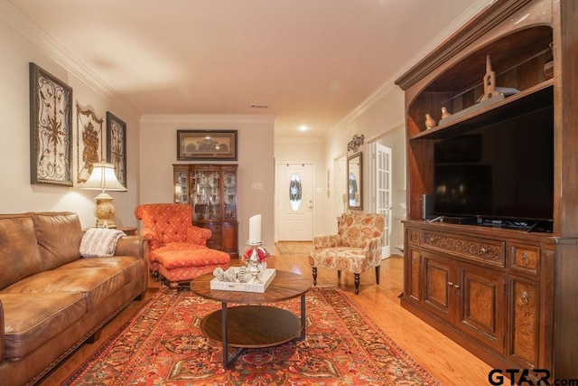 living room featuring crown molding and light hardwood / wood-style floors