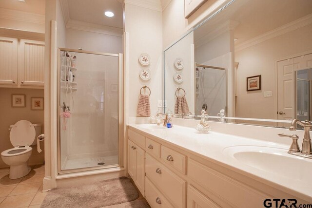 bathroom featuring tile patterned flooring, vanity, a shower with shower door, and crown molding