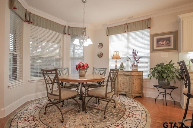 dining space featuring a chandelier, crown molding, and light hardwood / wood-style floors