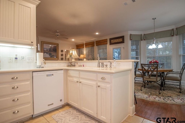 kitchen featuring kitchen peninsula, decorative light fixtures, ceiling fan with notable chandelier, and white dishwasher