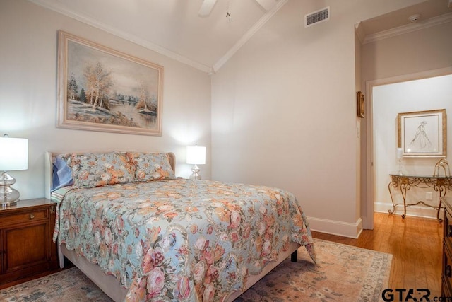 bedroom featuring ceiling fan, light hardwood / wood-style floors, lofted ceiling, and crown molding